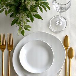 Elegant wedding table setting with gold cutlery and floral arrangements